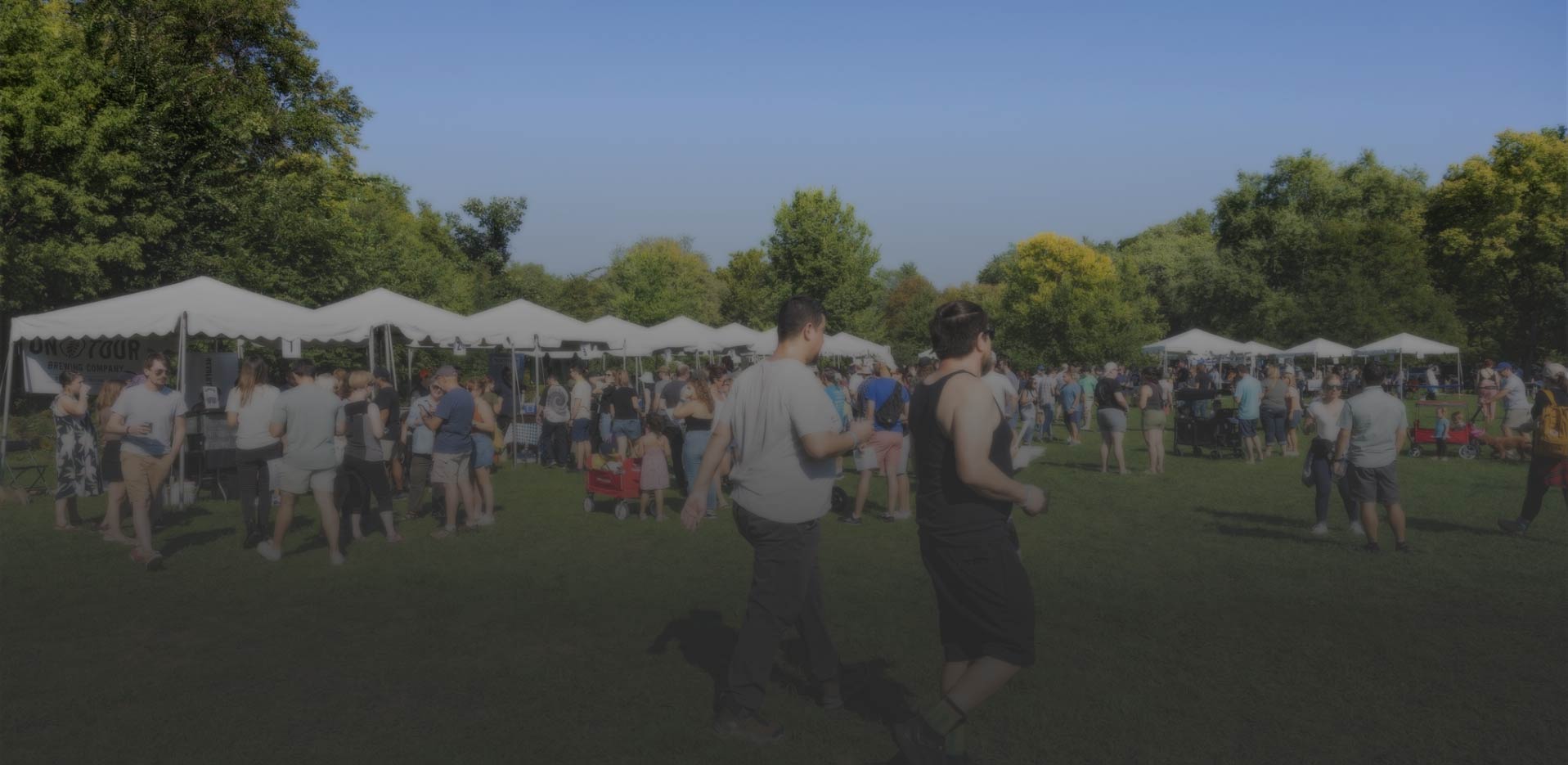 Photo of outdoor event with people and booths