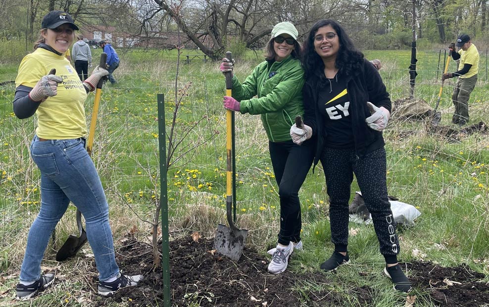 Members working on a digging project and smiling for the camera